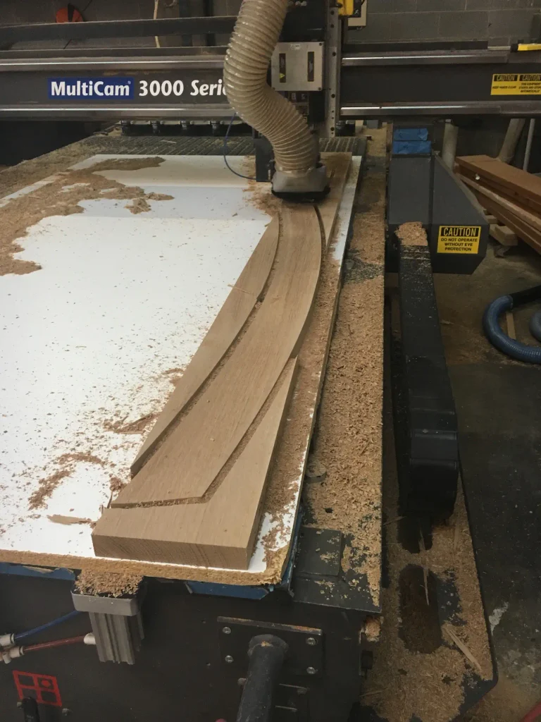 CNC machining custom curved wine racking components in shop
